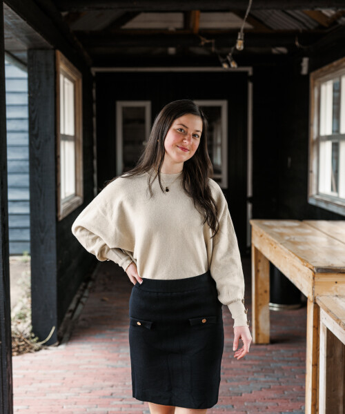 fijngebreid zwart recht rokje met goudkleurig detail en goudkleurig truitje vlindermouw 2