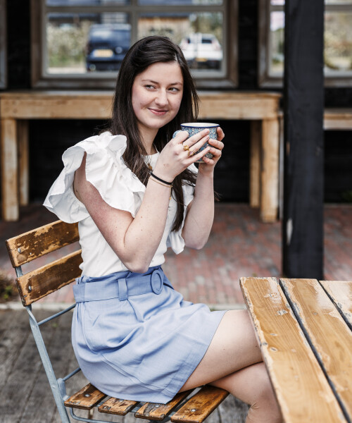 lichtblauw rokje met ceintuurje en offwhite shirtje met vrolijk mouwtje
