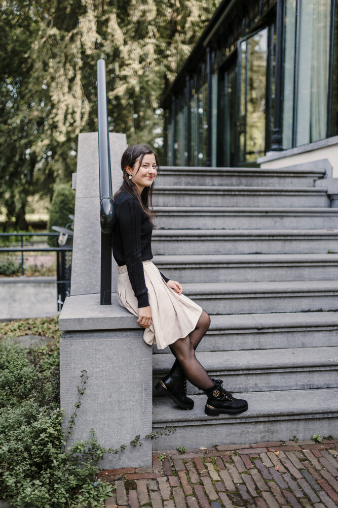 gevoerd rokje plooi zand en kabeltruitje zwart zitten 2